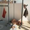 Free standing clothing rack in industrial design made from modern dark water pipes for children