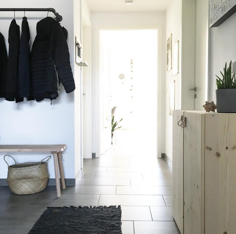 entrance area with simple clothes rail attached to the wall using dark water pipes modern design